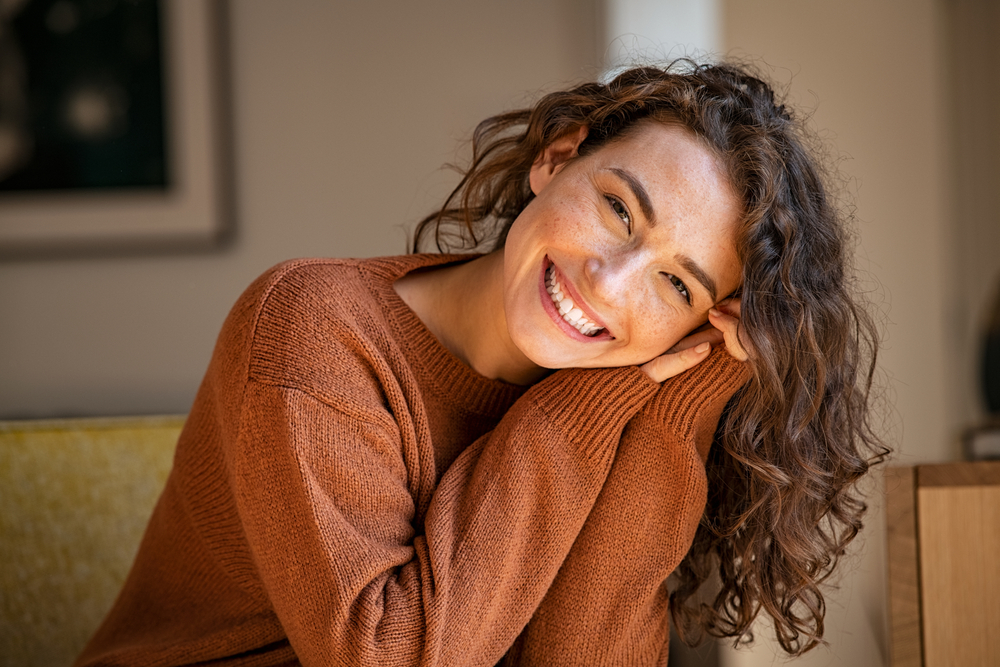 Smiling woman in a rust-colored sweater